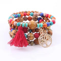 A vibrant tree of life tassel beaded bracelet set with wooden and turquoise beads featuring a red tassel charm