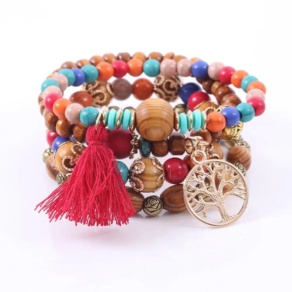 A vibrant tree of life tassel beaded bracelet set with wooden and turquoise beads featuring a red tassel charm