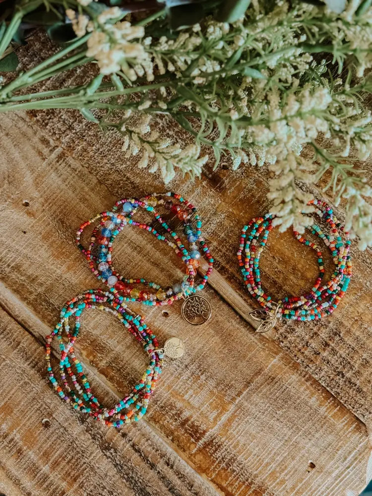 Multicolored glass bead stretch bracelets with metallic tree of life charms in a stacking bracelet set