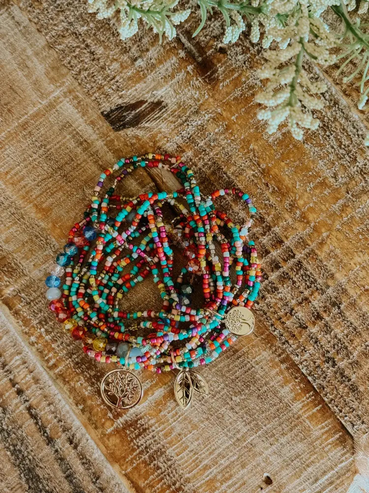 Colorful glass bead stacking bracelet set with multicolored tiny beads and gold-toned tree of life charms