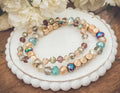 A pair of bohemian earth tone iridescent beaded stretch bracelets with gold metallic beads and glass crystals