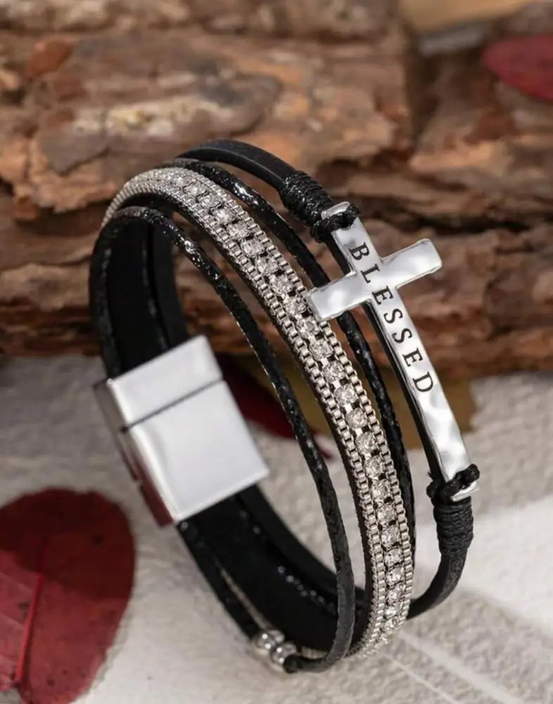 Black leather multi strand bracelet with silver cross charm engraved with blessed and embedded crystals