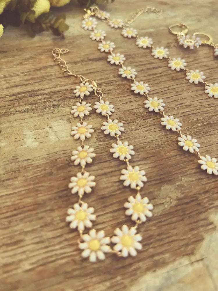 Gold daisy enamel necklace and earrings jewelry set with delicate gold-toned chain and white enamel flowers with yellow centers