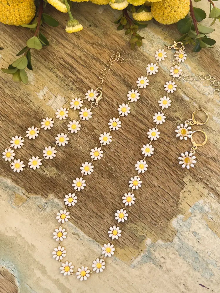 Gold daisy enamel necklace and earrings jewelry set with white enamel petals and yellow centers in gold tone
