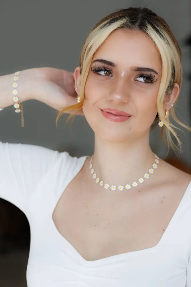 Gold daisy enamel necklace with delicate gold chain and tiny flower charms in jewelry set with matching earrings