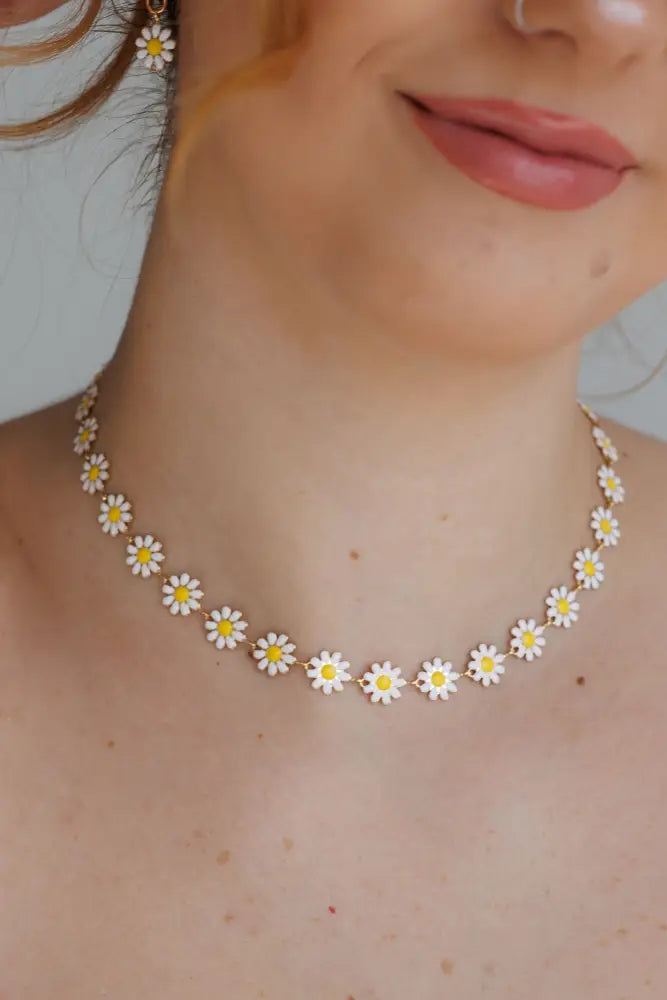 Gold daisy enamel necklace and earrings set featuring a delicate gold-toned choker with white and yellow daisy charms