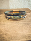 Layered green gemstone and leather magnetic bracelet set with dark leather bands gold-toned clasps and green gemstone strand
