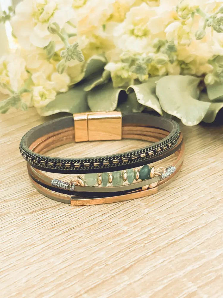 Layered green gemstone and leather magnetic bracelet with multi-layered leather bands gold-toned clasp and green stone accents