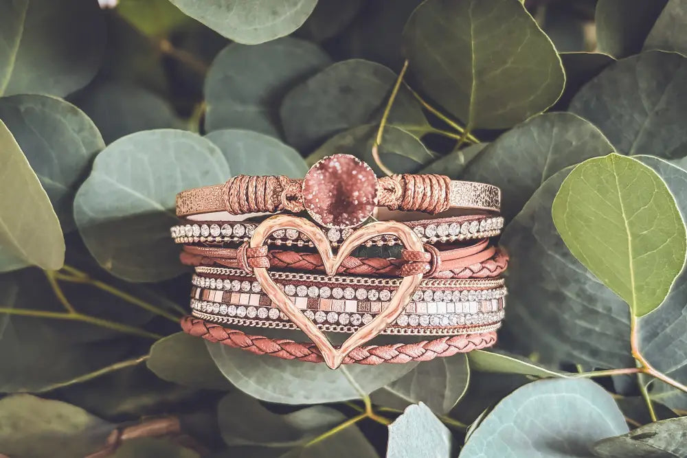 Rose gold heart charm bracelet with braided leather straps and sparkling rhinestone crystal accents