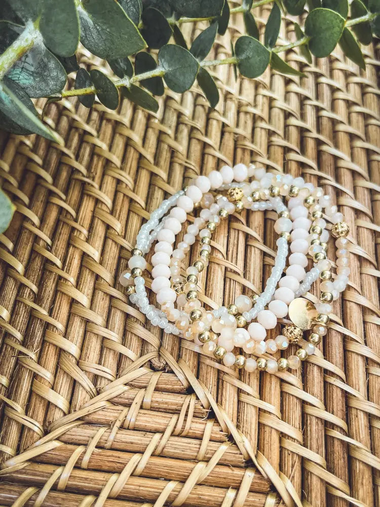 Elegant pink and gold beaded stacking bracelet set featuring delicate soft white and pale blue beads with gold accents