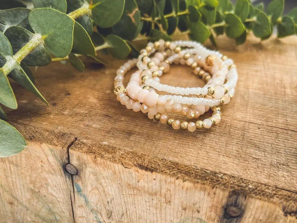 Elegant pink and gold beaded stacking bracelet set with soft pink and white faceted beads and gold-toned accents