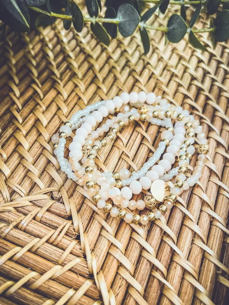 Elegant pink and gold beaded stacking bracelet set featuring delicate white and gold glass beads with metallic accents