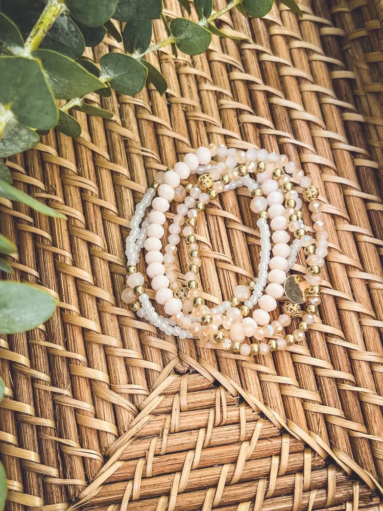 Elegant pink and gold beaded stacking bracelet set with soft pink and white pearls and gold-toned metallic beads