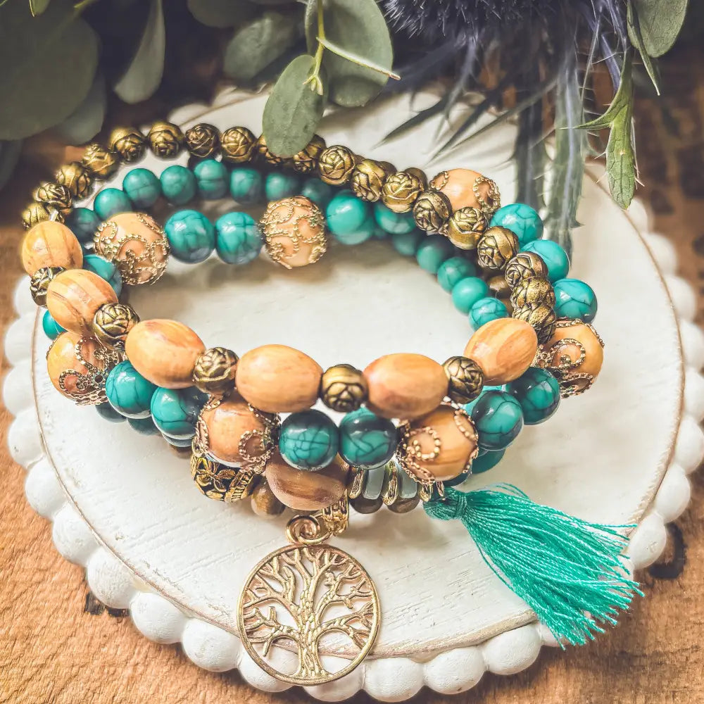 Turquoise tree of life and wood beaded bracelet set featuring turquoise and amber beads with gold-toned charm and tassel