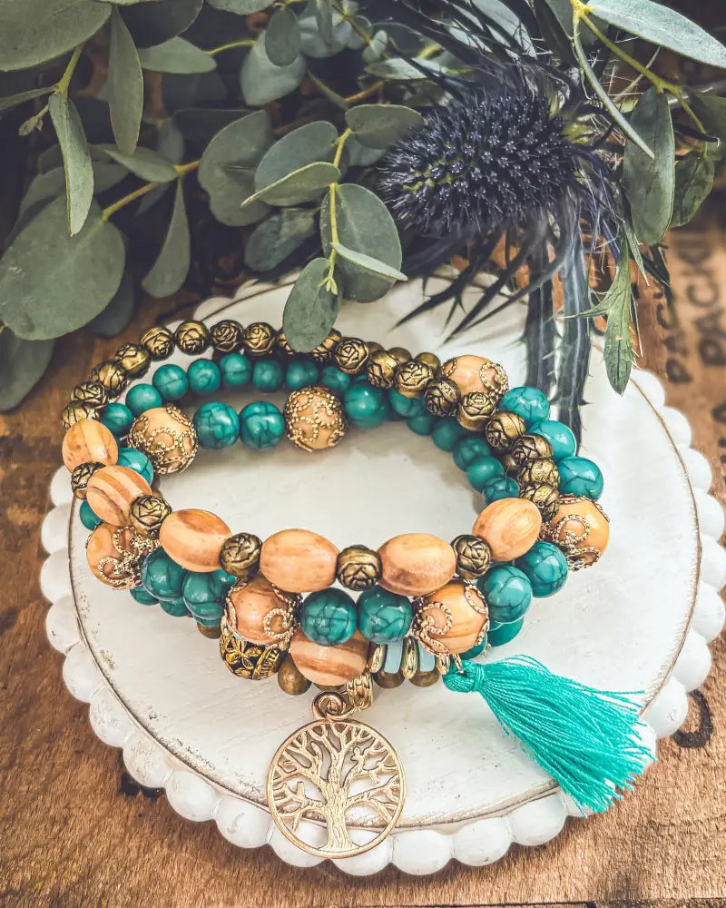 Turquoise tree of life wood beaded bracelet set with teal and peach wrap bracelet featuring gold-toned charm and tassel