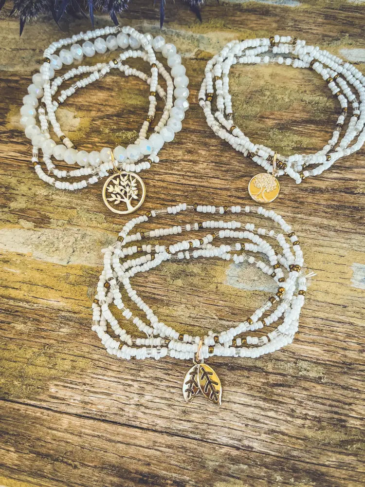White and gold tree of life beaded stacking bracelet set with three layers featuring metal tree and leaf charms