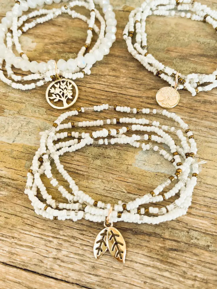 White and gold tree of life beaded stacking bracelet set with white beads and gold toned tree and leaf charms