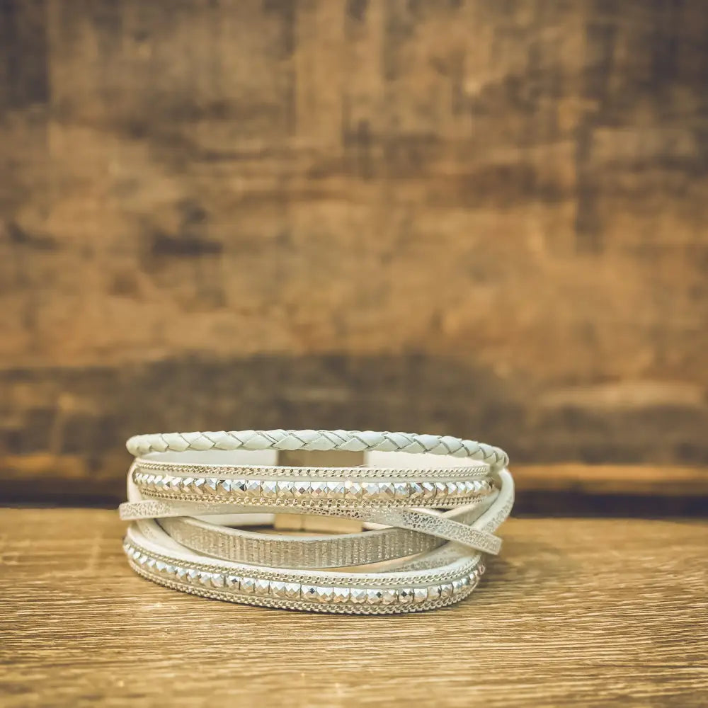 White layered leather wrap bracelet with braided design and silver-toned rhinestone accents