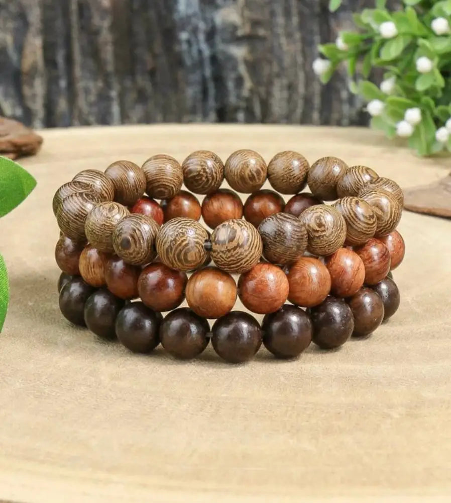 Natural amber and brown wood bead stacking bracelet set with three bracelets featuring natural wood grain patterns