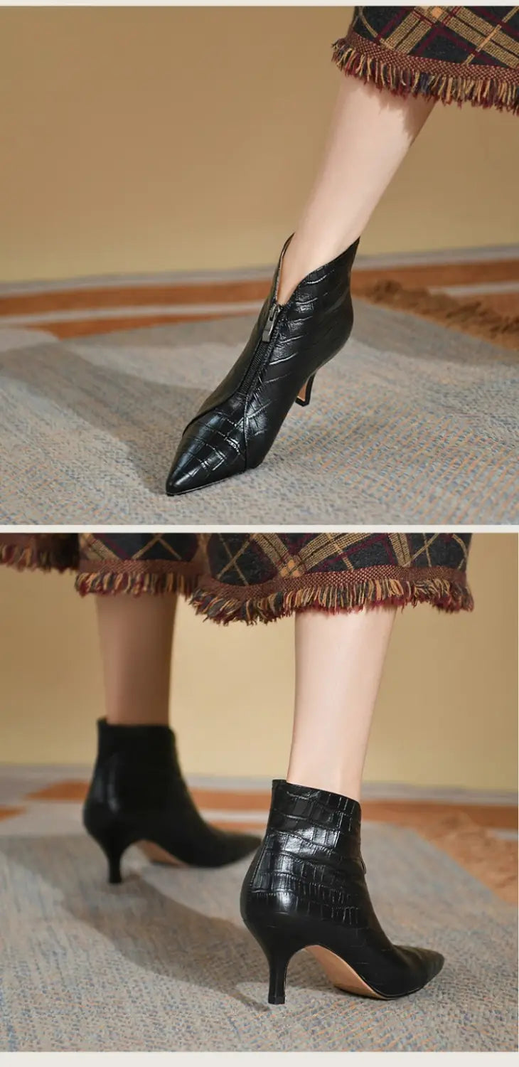Black croc embossed leather stiletto ankle boots with a pointed toe and slender heel shown from the back side.