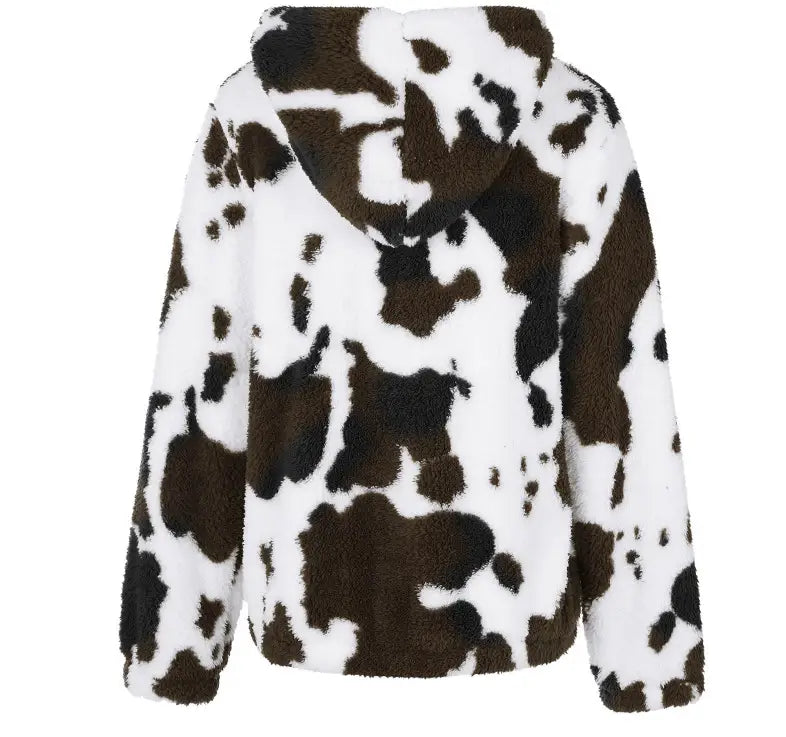 Una chaqueta acolchada tipo zip-up acogedora con un patrón destacado de vaca negro y blanco, elaborada con material suave para una colocación cómoda