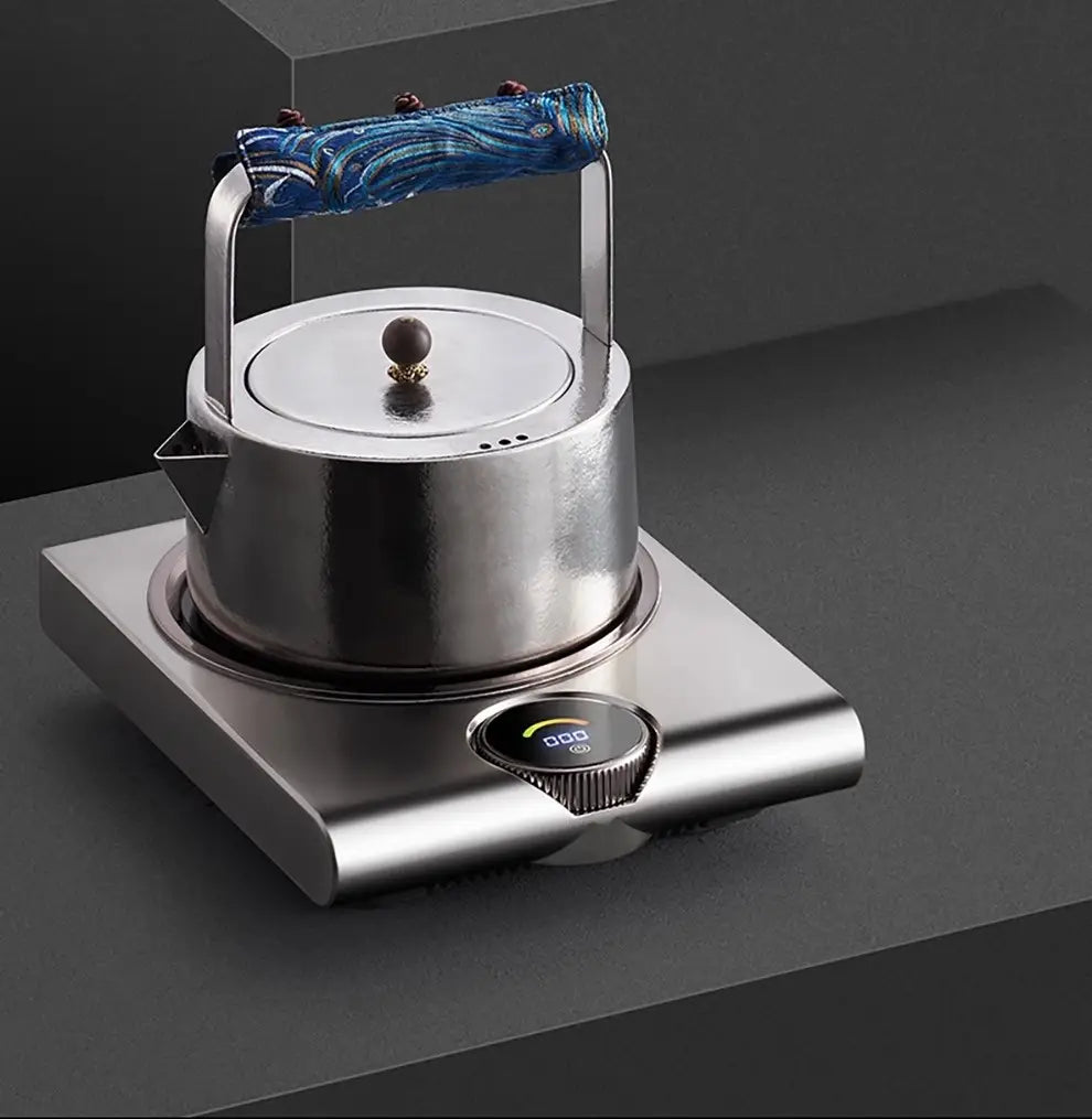 A sleek stainless steel electric ceramic stove 1000w tea cooker kettle with a blue patterned handle sits atop a matching electric base.