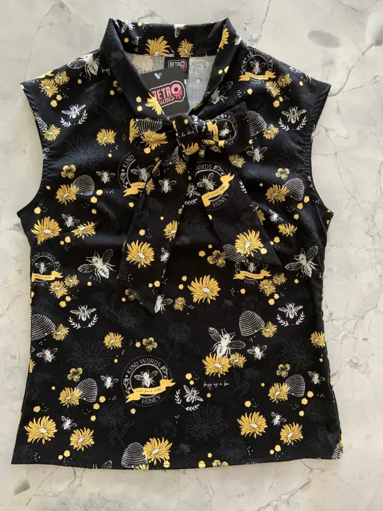 Black sleeveless cotton blouse with yellow white bee pattern and bow neckline inspired by 1950s fashion