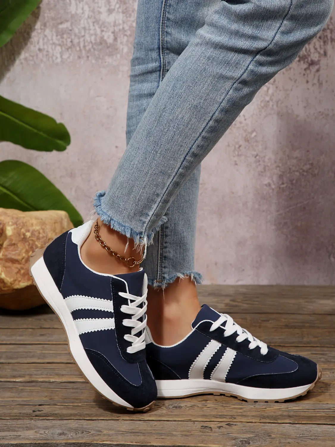 Dunkelblaue und weiße Damen-Retro-Chunky-Sneaker mit atmungsaktivem Veloursleder mit niedrigem Schaft und drei parallelen Streifen an der Seite.
