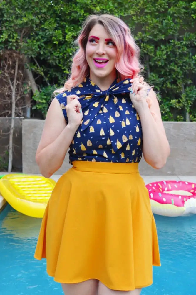 Navy blue and gold vintage beehive print sleeveless cotton blouse with a bow at the neckline