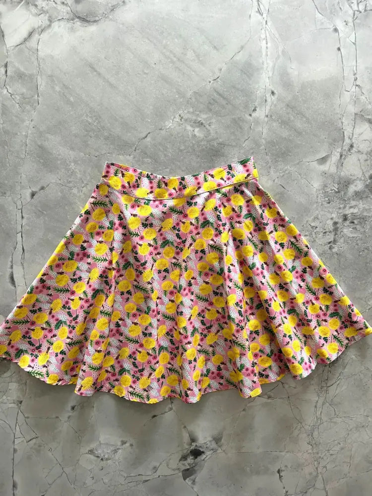 Bees and dandelions pink floral cotton skater skirt with a flared design and vibrant yellow and pink flowers with green stems