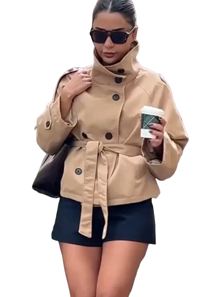 Beige double breasted trench coat in tan with a belted waist and dark buttons for a classic outerwear look