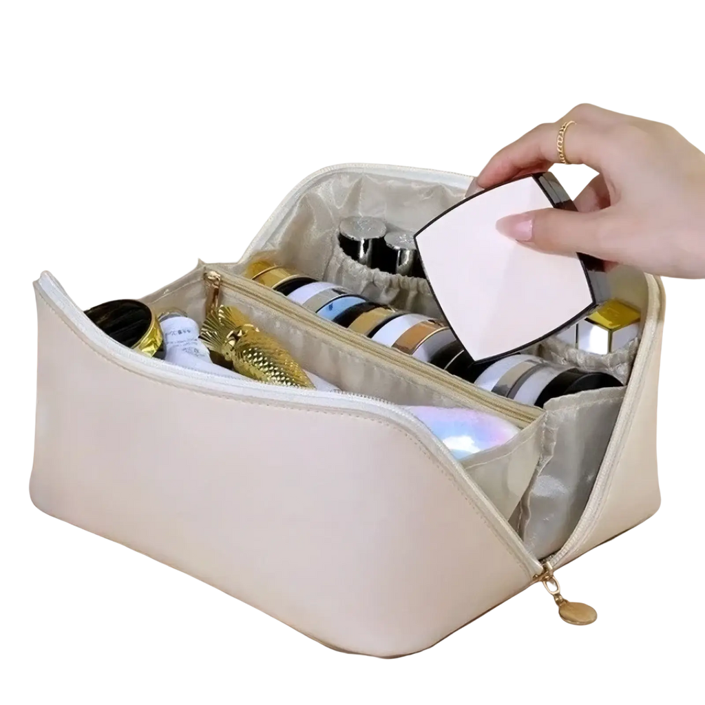 Beige fabric travel makeup bag with gold zipper and interior compartments holding various cosmetics for toiletry organization