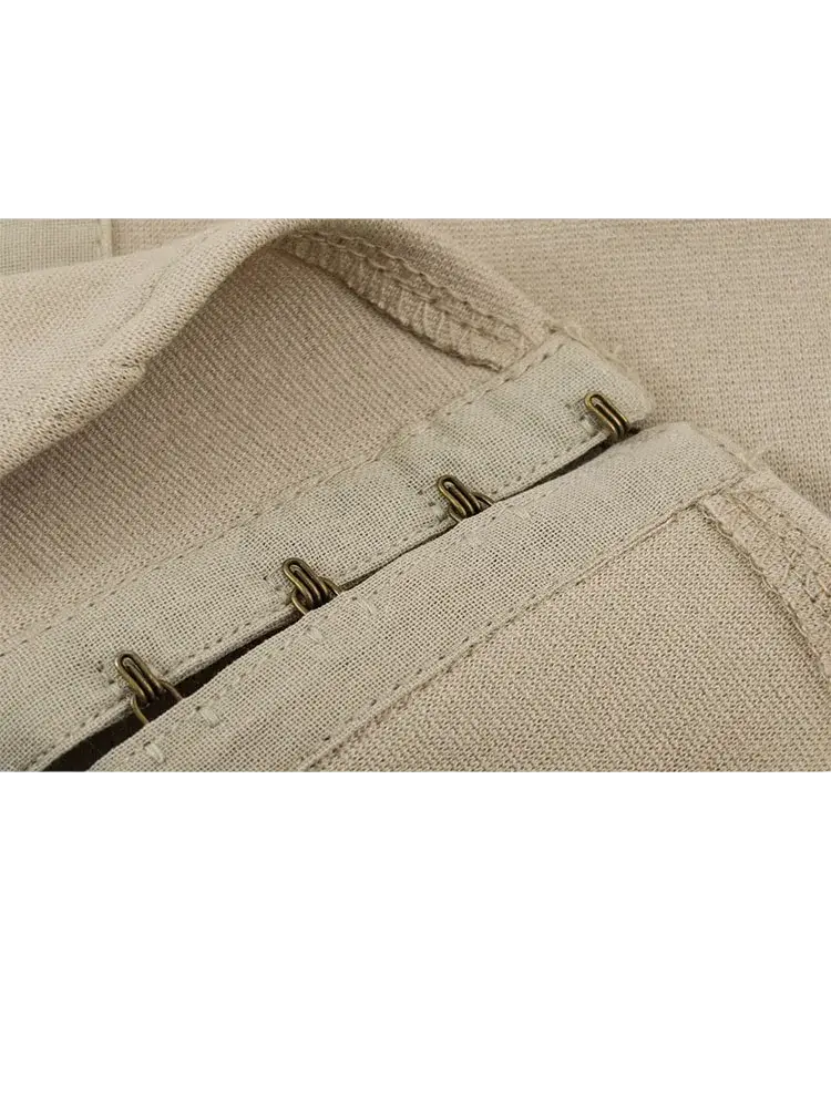Beige puffed sleeve cropped corset top made of canvas with brass-colored metal eyelets and reinforced stitching