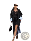 Black leather handbag with chain strap paired with beige trench coat featuring elegant striped lining outerwear