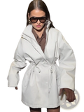 A white oversized trench coat with a belted waist and wide sleeves in a beige utility style