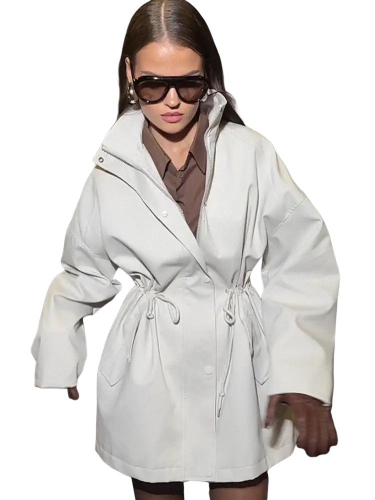 A white oversized trench coat with a belted waist and wide sleeves in a beige utility style