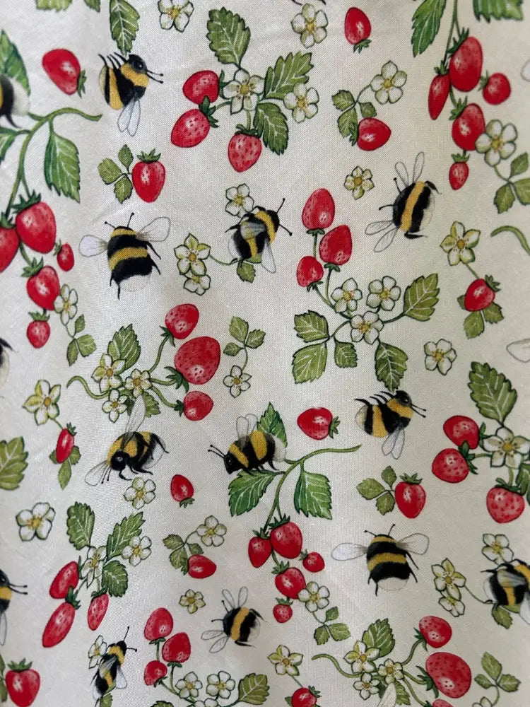 Cream-colored 1950s vintage cotton sleeveless dress with pockets featuring strawberries bees and floral pattern