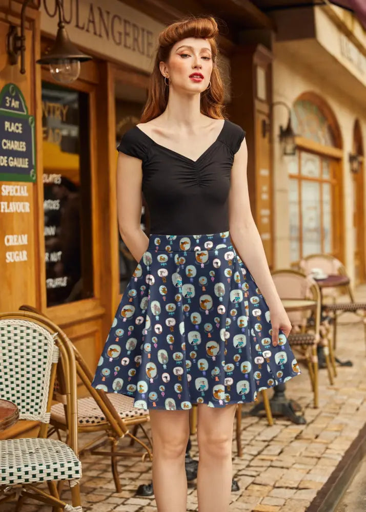A navy blue best in show dog print pleated skater skirt with playful cartoon character oval frame pattern