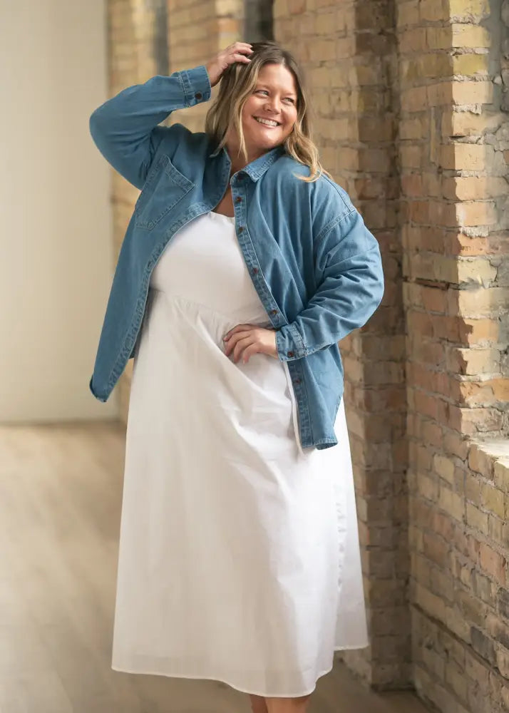 White flowing dress paired with blue denim betty denim relaxed button up shirt with button details