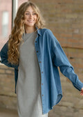 Betty denim relaxed button up shirt in blue denim worn over a gray dress showcasing casual layering style