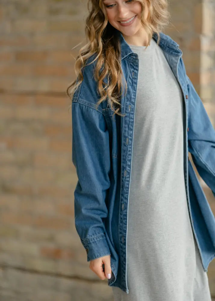 Blue denim relaxed button up shirt worn over gray dress showcasing casual layering with durable cotton fabric