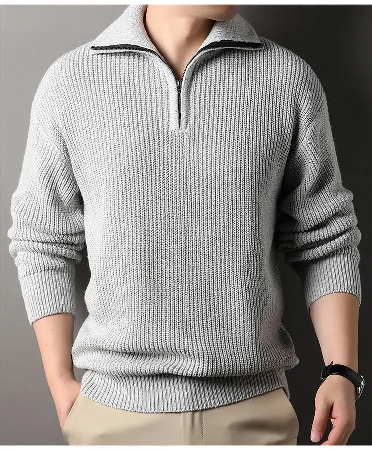Herren-Halbrollkragenrippstrickpullover aus hellgrauem Strickstoff mit Halb-Zippkragen und schwarzer Zippverschluss-Verarbeitung.