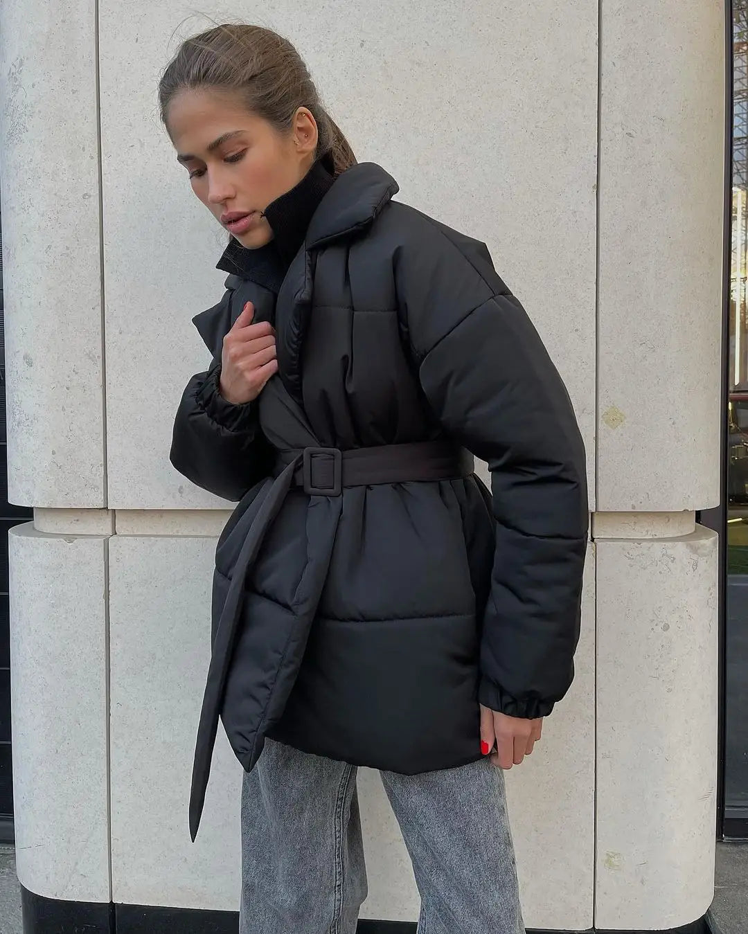 Schwarze Damen-Gurtsteppjacke mit Kapuze, wattierte Pufferjacke mit Taillengürtel und für Winterbekleidung konzipiert.