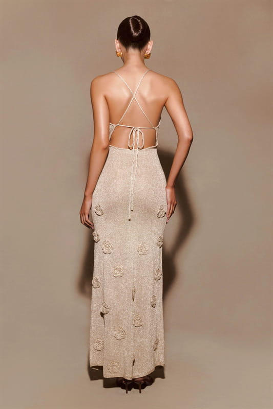 beige crochet floral lace mermaid maxi dress with glitter accents shown from the back featuring floral embellishments and a tie-up design