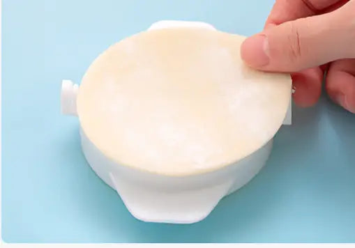 White plastic dumpling maker 3 in 1 manual dough pressing tool with a round flat lid and side handles.