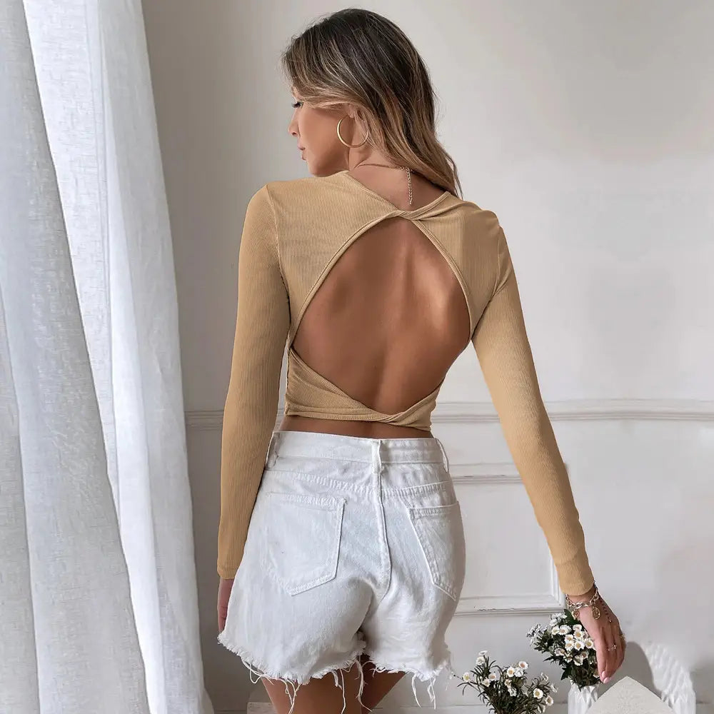 Beige ribbed slim fit long sleeve crop top shown from the back with a cross-cutout design.