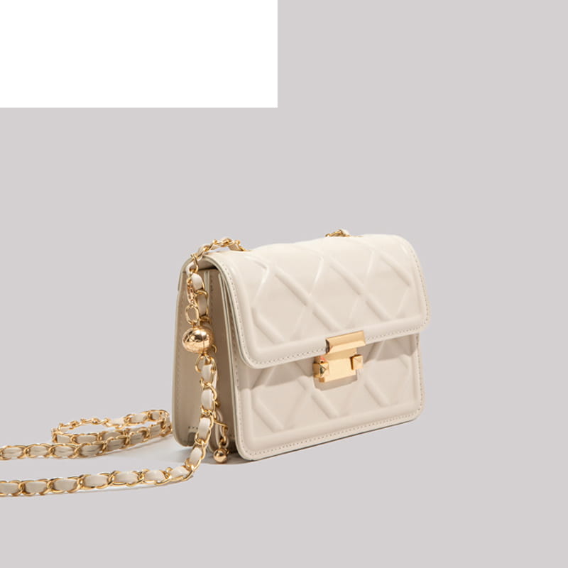 Cream-colored quilted crossbody bag made of leather with a gold-tone chain strap and clasp.