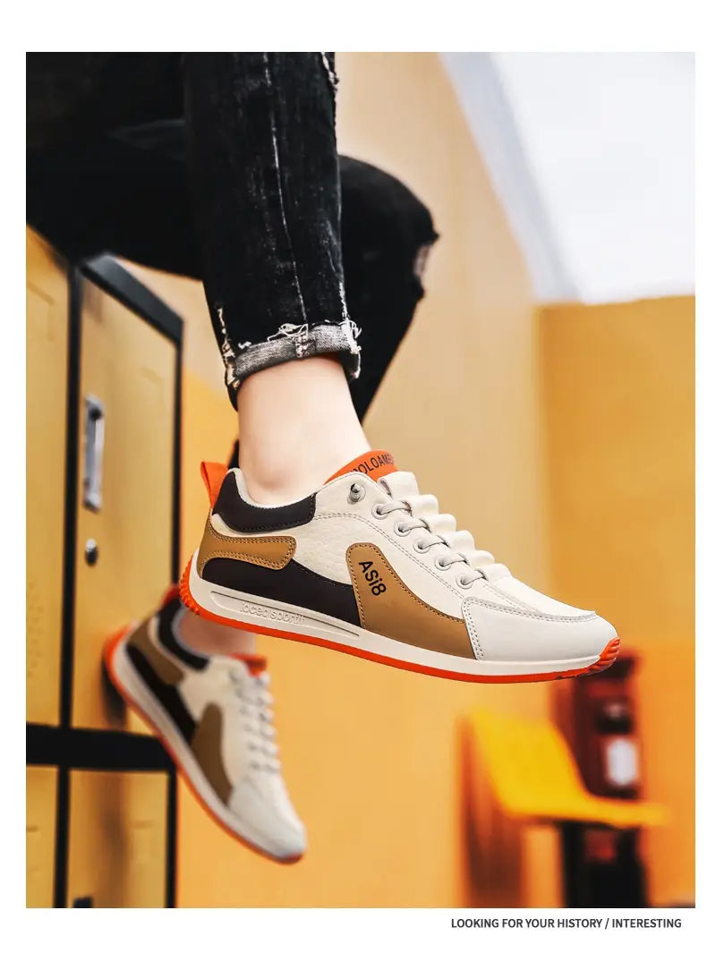 Men’s casual sports sneakers non-slip microfiber shoes in white and tan with black accents and orange detailing on the heel tab and sole shown from the back.