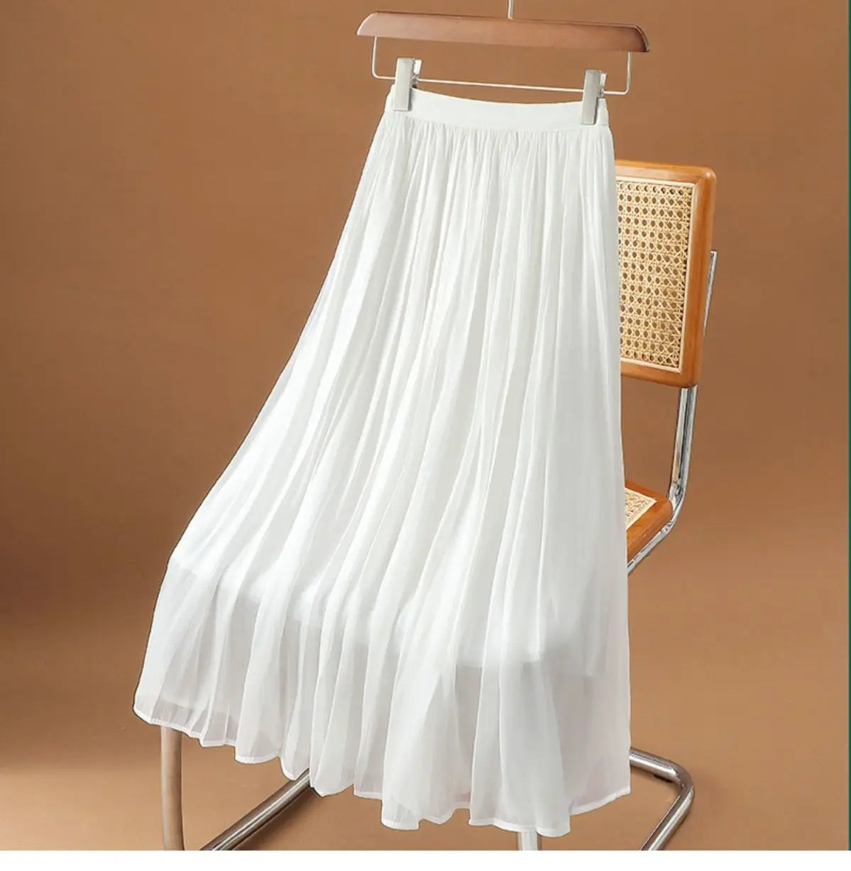 weißer irrisierender Chiffon-Faltenrock, der an einem Holzkleiderbügel hängt und von vorne präsentiert wird