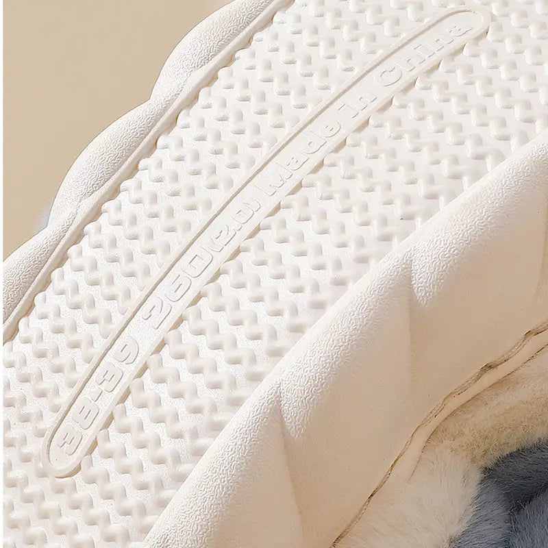 White rubber sole with a textured grid pattern and embossed branding on the Shark Slippers plush animal dolphin whale house shoes.